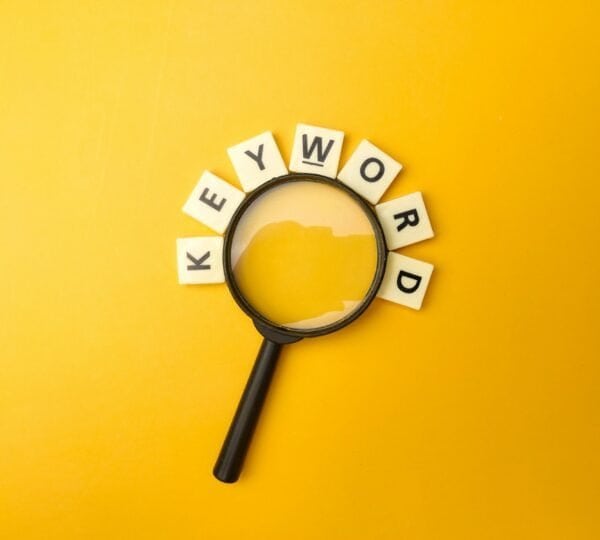 Magnifying glass and toys word with the word KEYWORD on yellow background